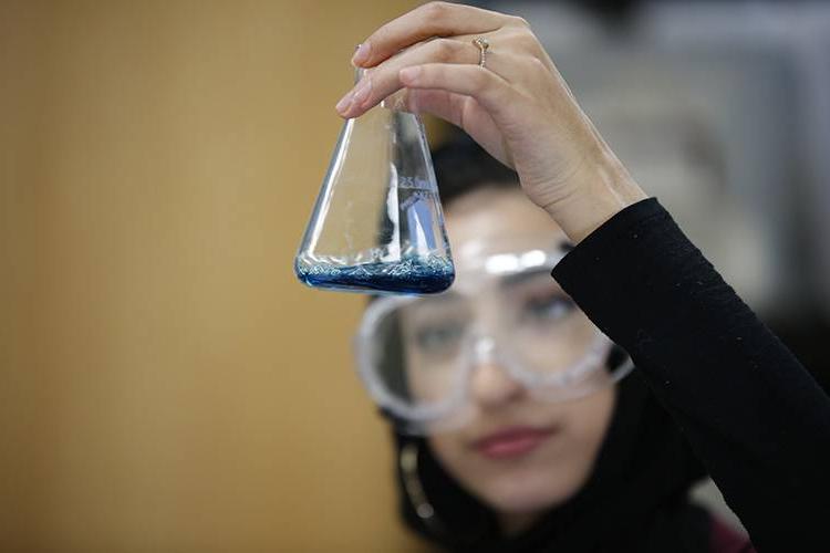 High student holding a beaker in a science lab